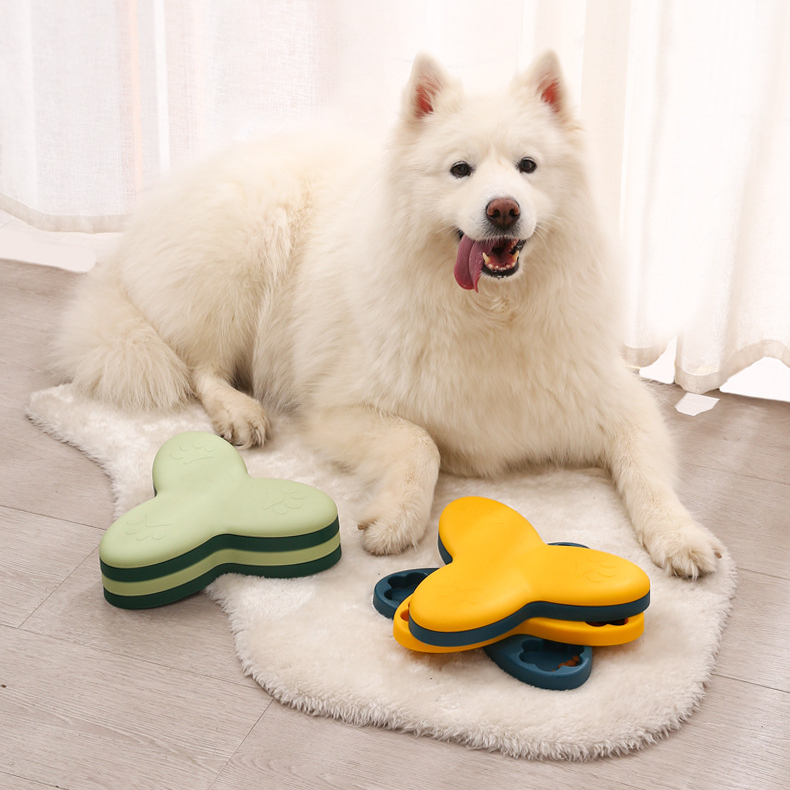 White Samoyed dog sitting on a rug with interactive feeding toys, designed for dog boredom relief and healthy eating habits.